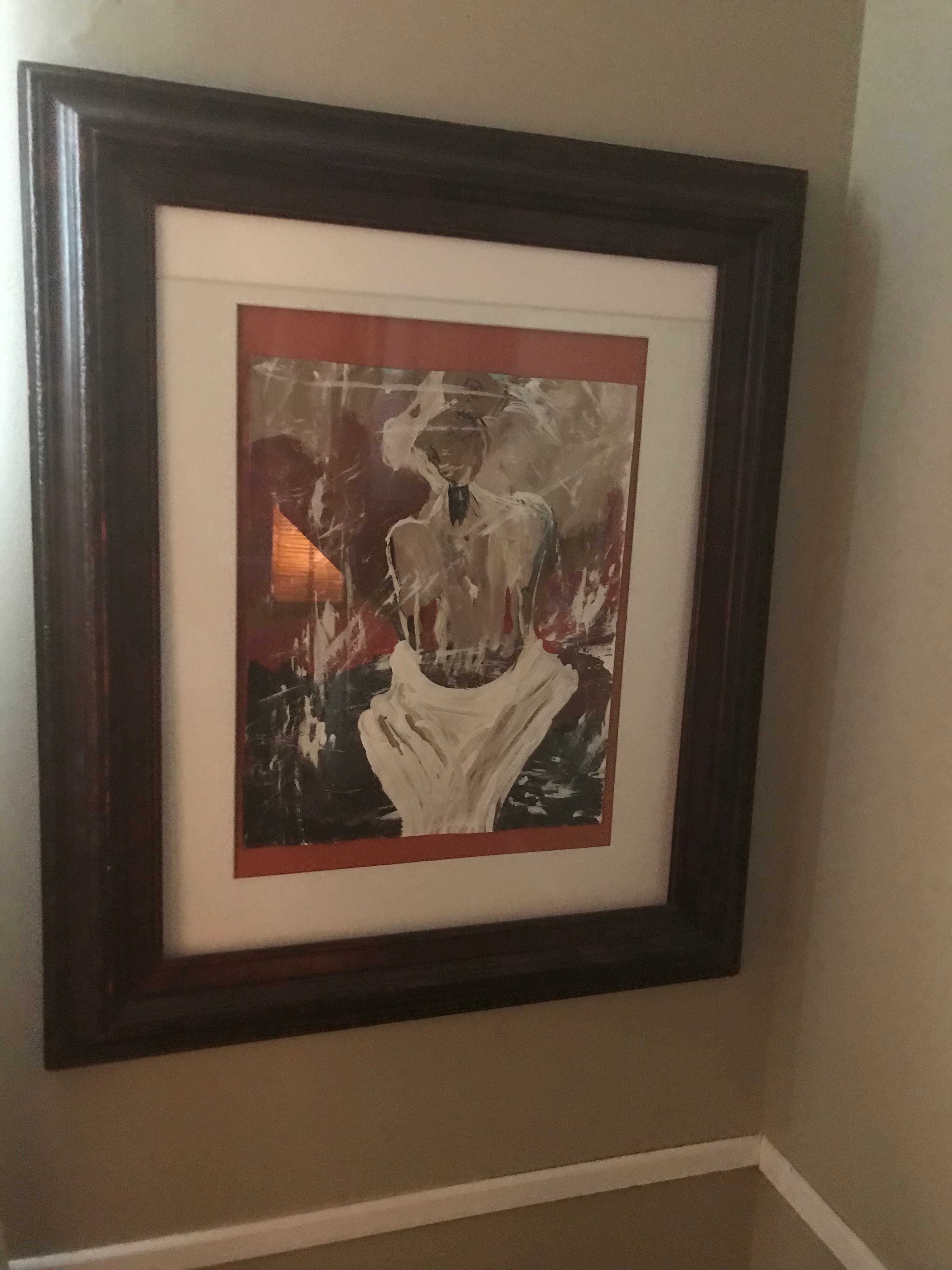 Abstract painting with expressive white, black, and red brushstrokes in a dark wood frame.