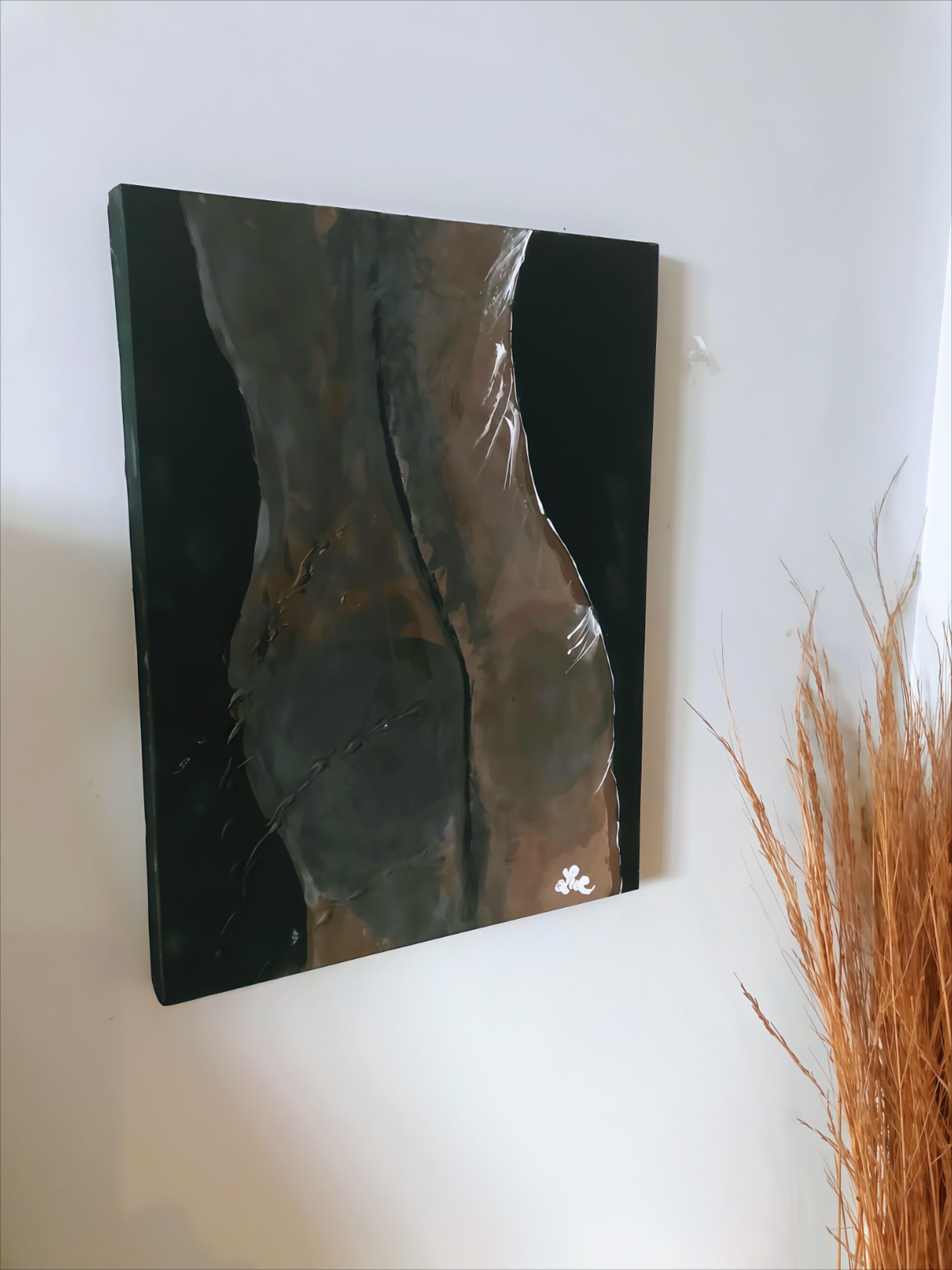 Abstract painting of a human torso hanging beside dried grass on a white wall.